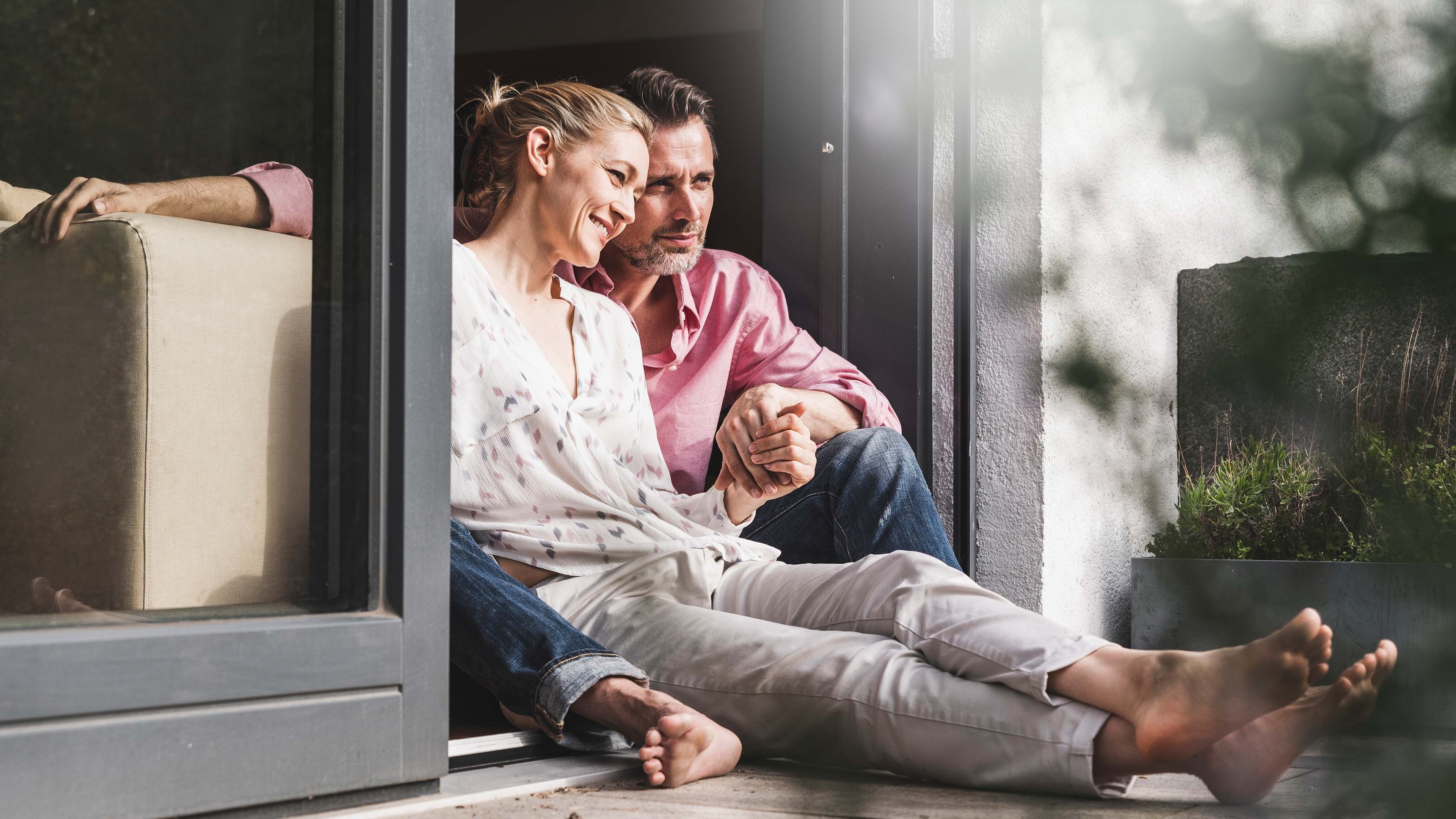 Paar sitzt auf der Fensterbank und diskutiert die wertvollen Tipps zur Steuern Optimierung