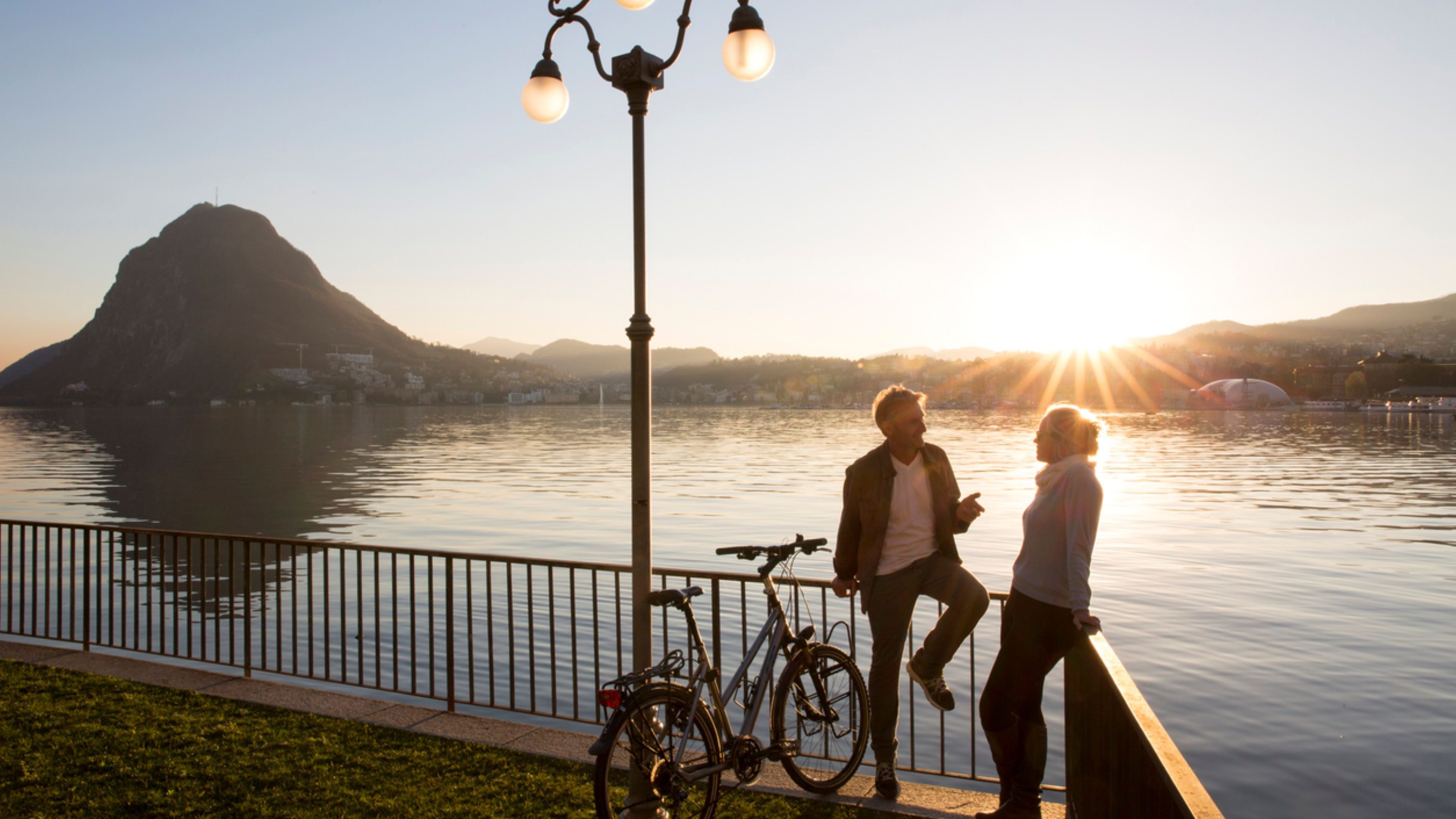 Ein Mann und eine Frau stehen am See und unterhalten sich über die Teilpensionierung