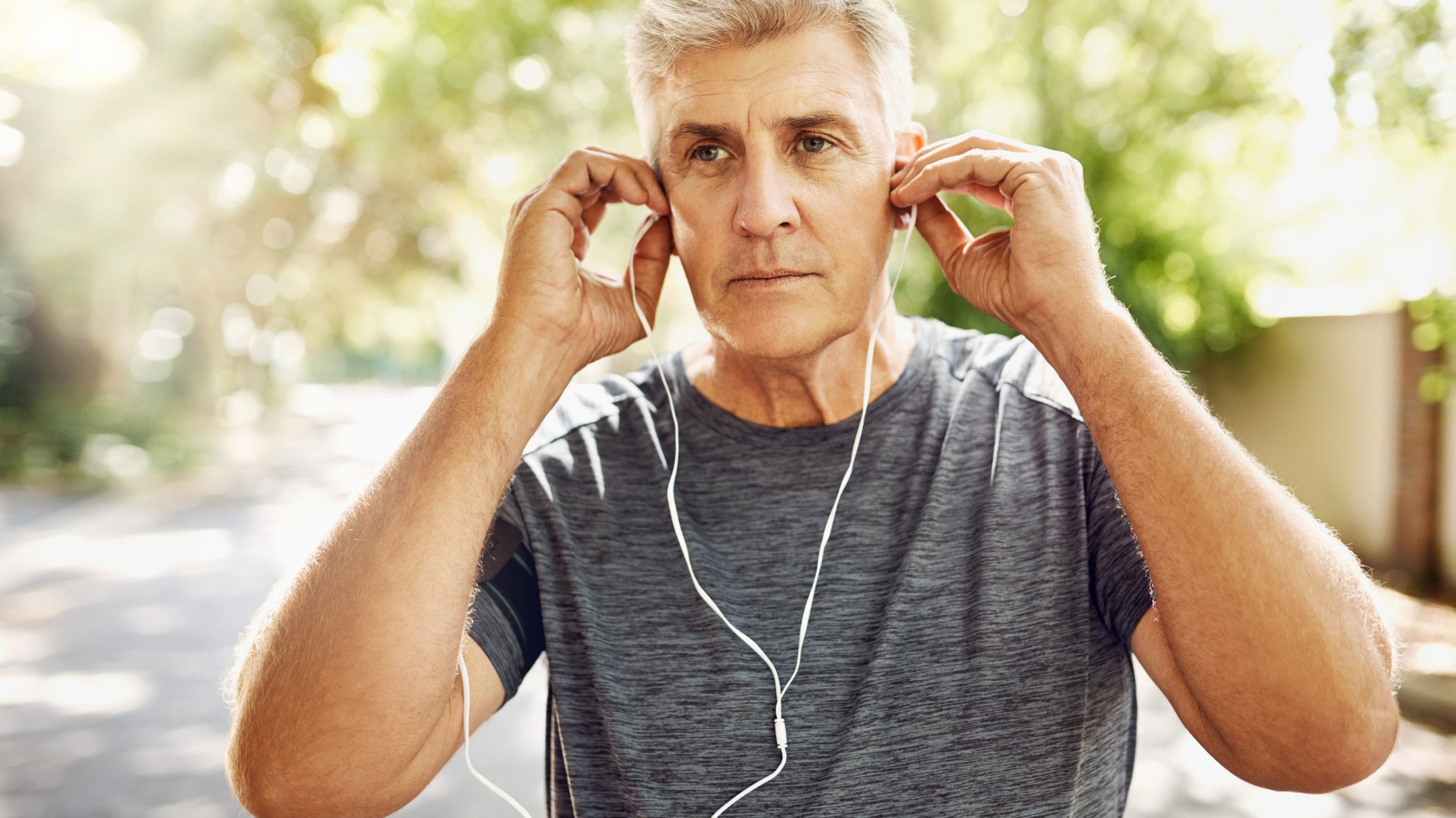 Mann mittleren Alters hört beim Joggen einen Beitrag zur Altersvorsorge.